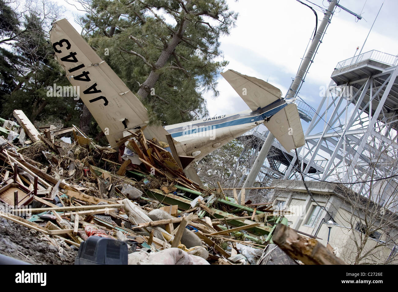 A wrecked plane lies among debris at Sendai Airport, Japan, in the aftermath of the March 2011 earthquake + tsunami. Stock Photo