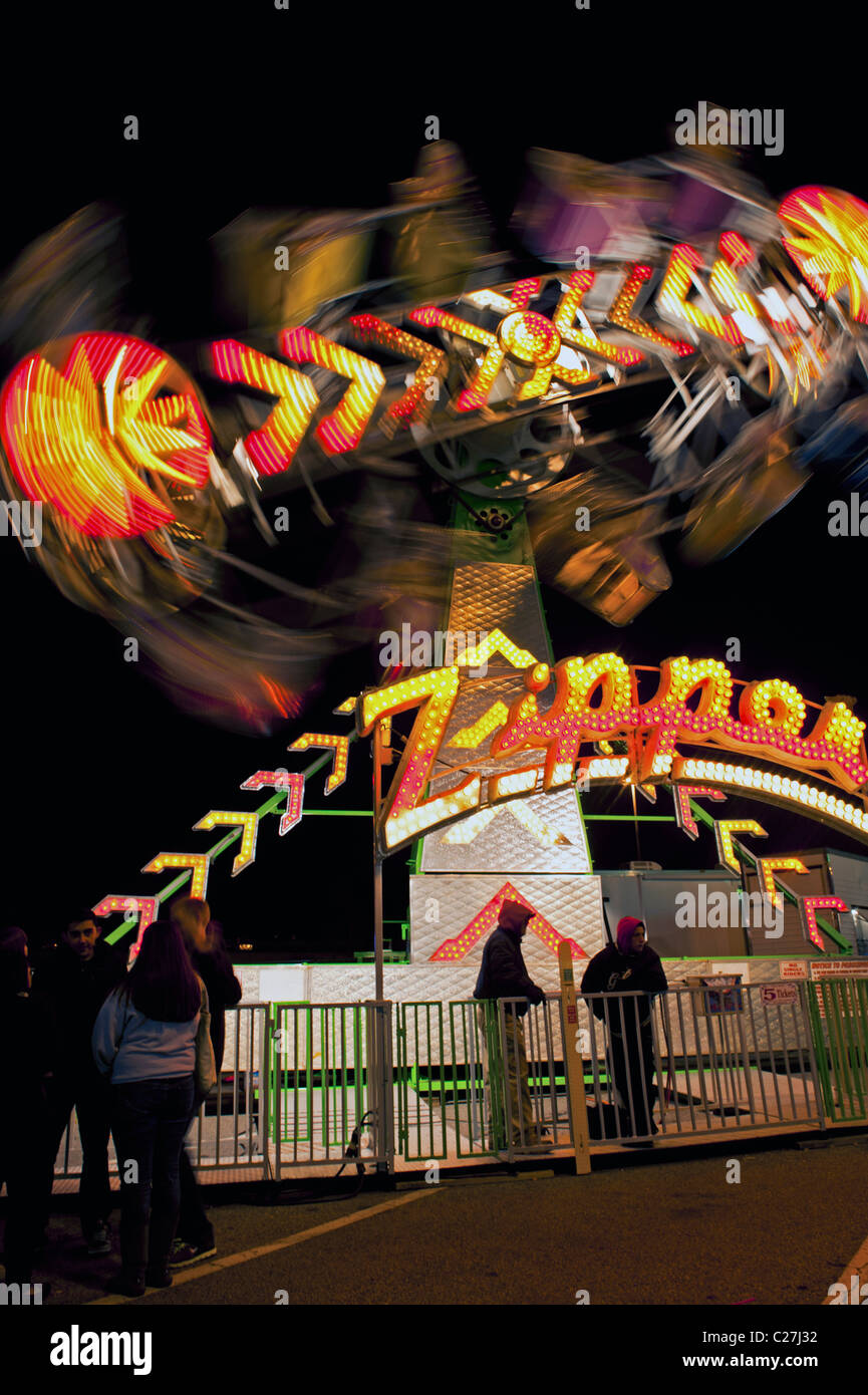 Fast moving ride at a carnival amusement park fair Stock Photo