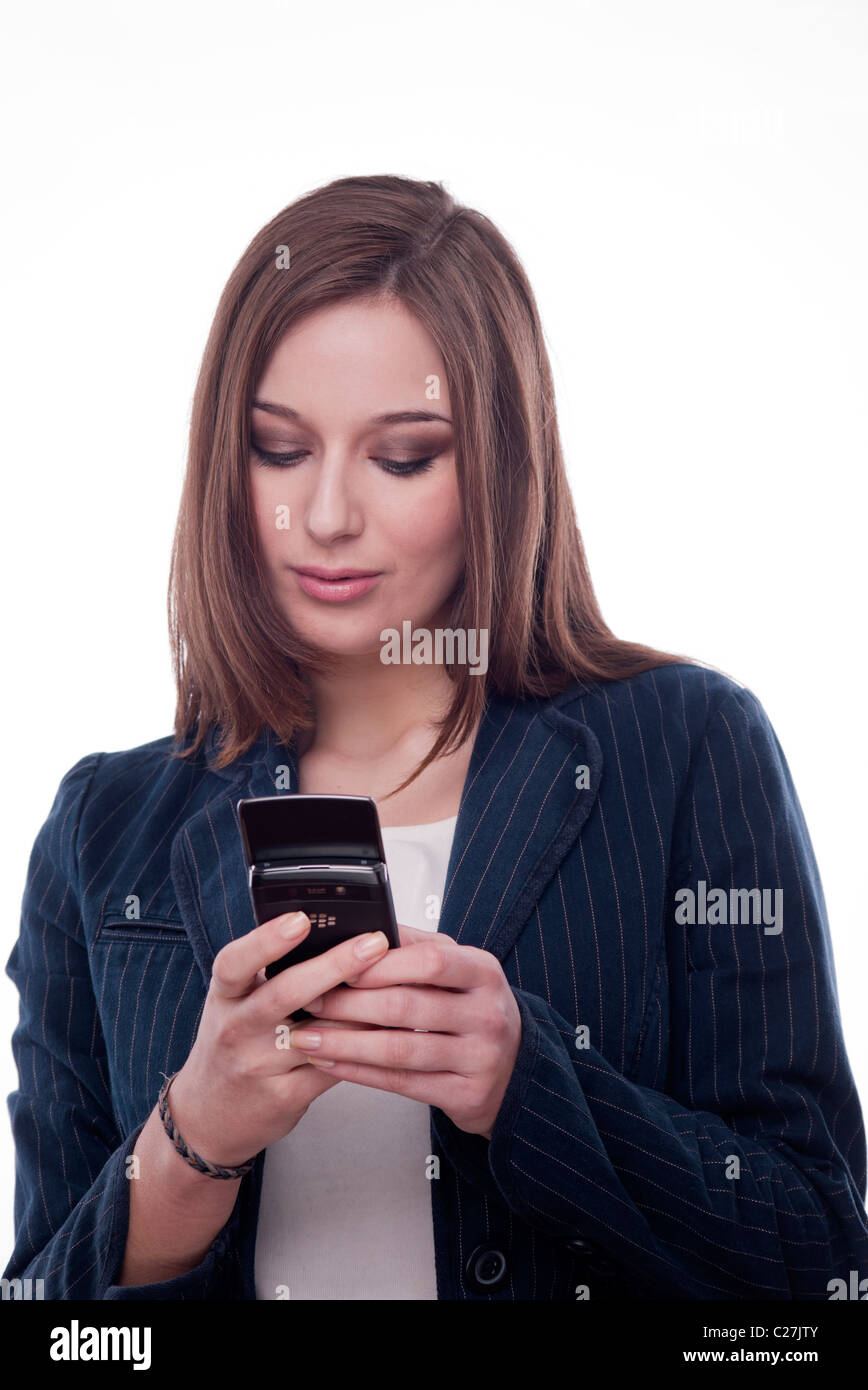 Brunette woman texting or sending an email on a blackberry mobile phone Stock Photo