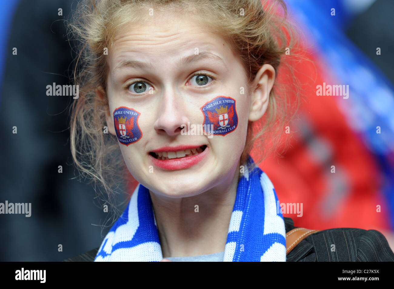 Attractive female football supporter wearing Carlisle United club badge transfers on her face Stock Photo