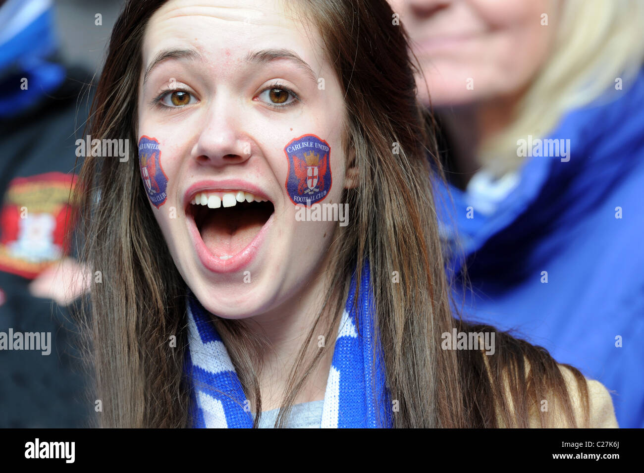 Attractive female football supporter wearing Carlisle United club badge transfers on her face Stock Photo