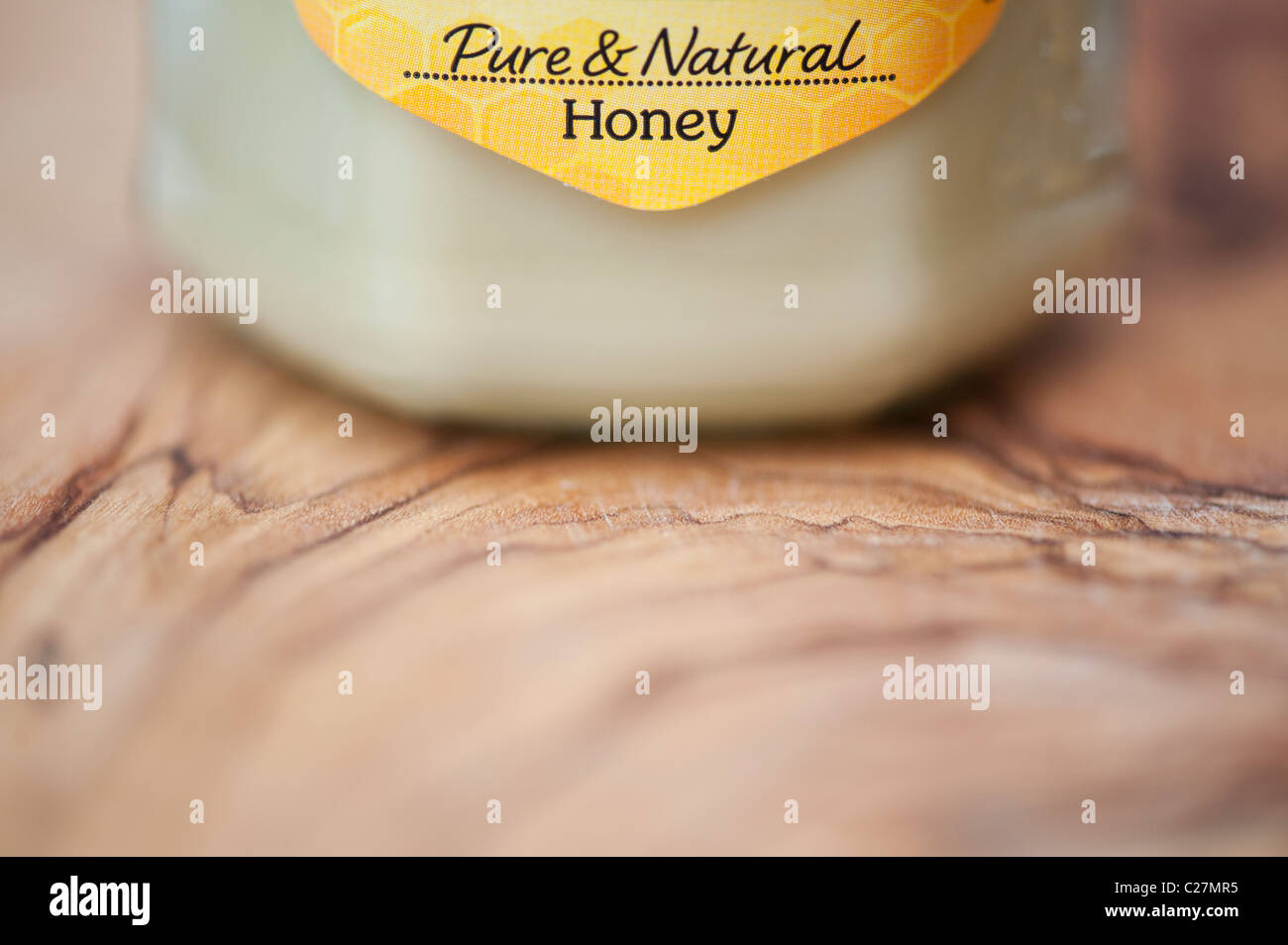 Rowes Pure natural honey jar on olive wood board Stock Photo