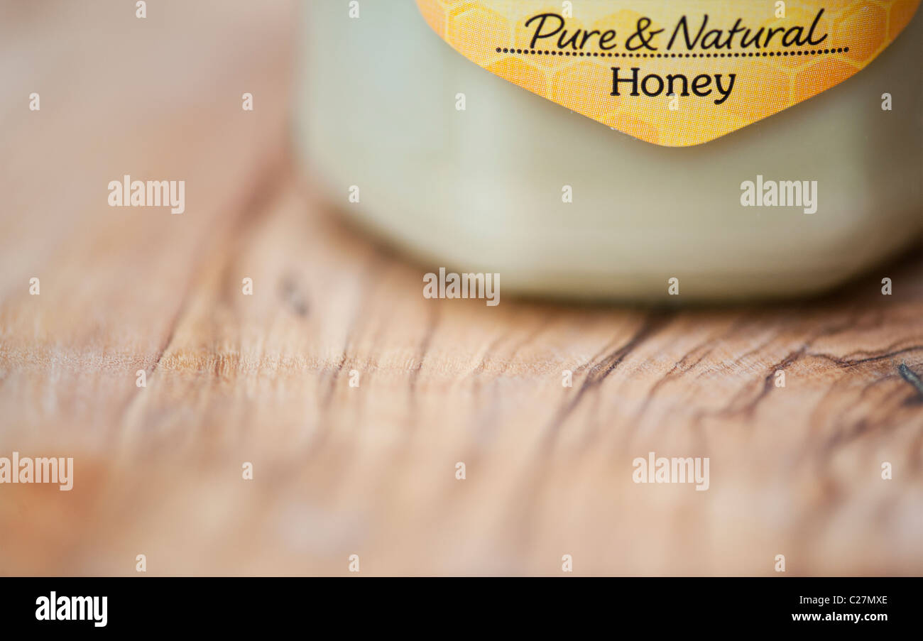 Rowes Pure natural honey jar on olive wood board Stock Photo