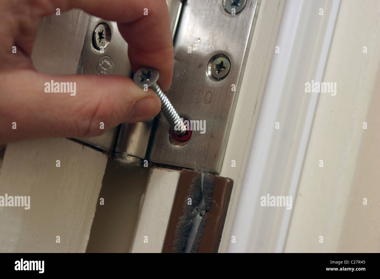 fitting a hinge onto a door frame Stock Photo Alamy