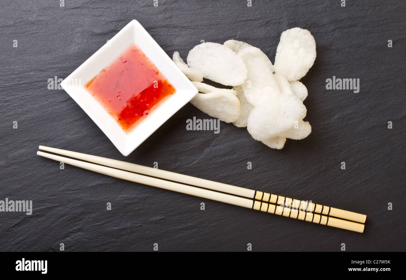 Prawn crackers also known as chinese crackers with sweet chilli dipping sauce. Stock Photo