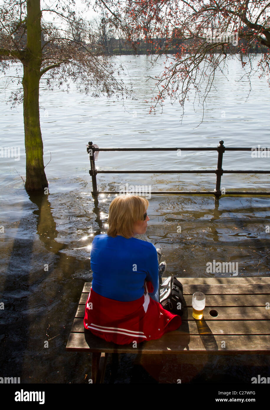 Customer trying to keep her feet dry at high tide at the City Barge pub in Chiswick Stock Photo