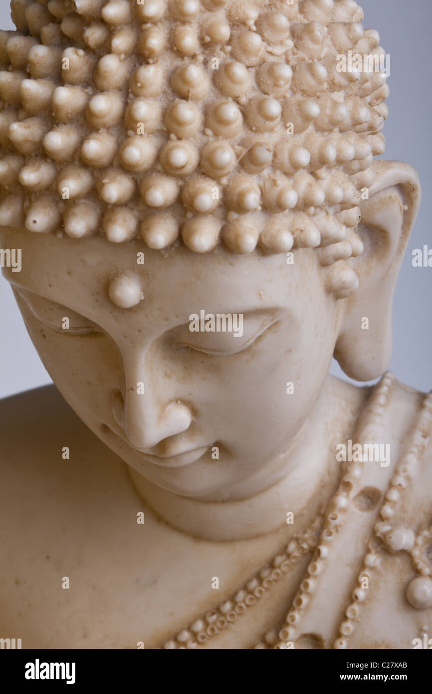 Close up of Buddah statue face against dark background. Stock Photo