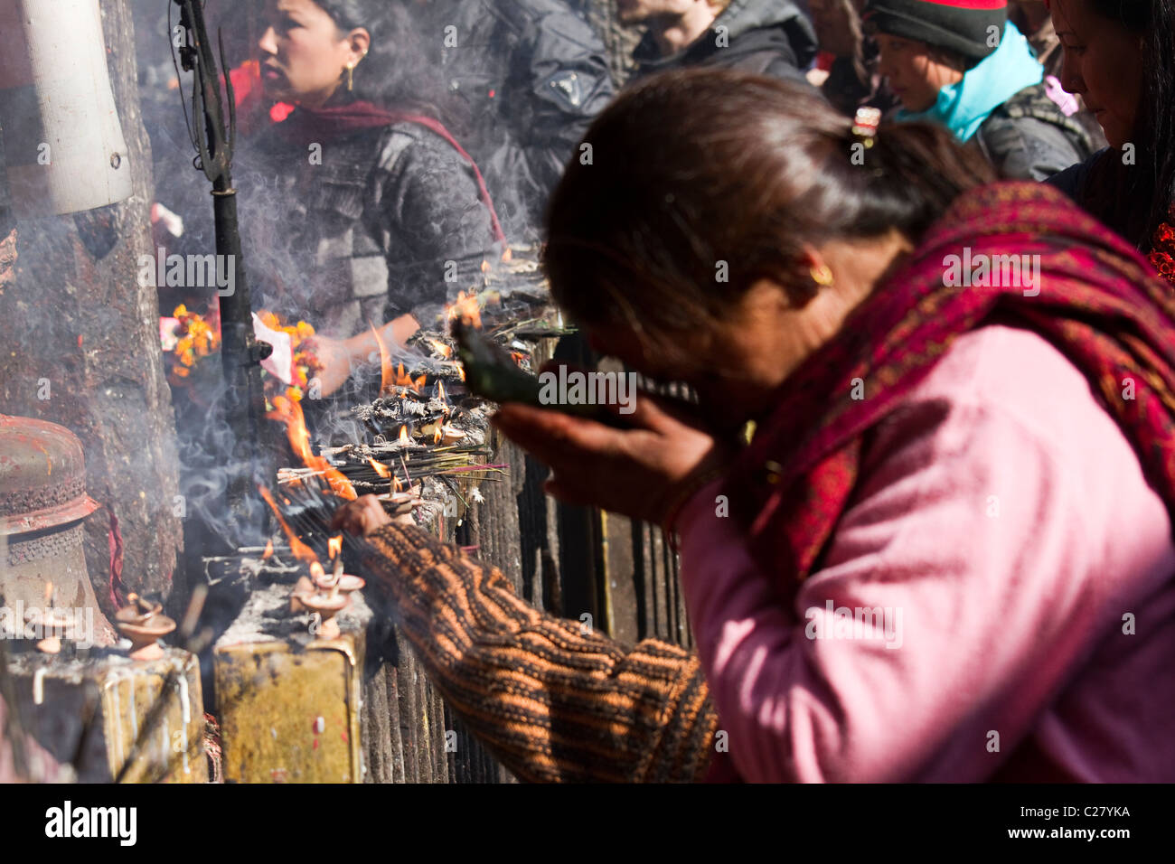 Woman Praying And Incense Sticks Burning In A Temple In Kathmandu