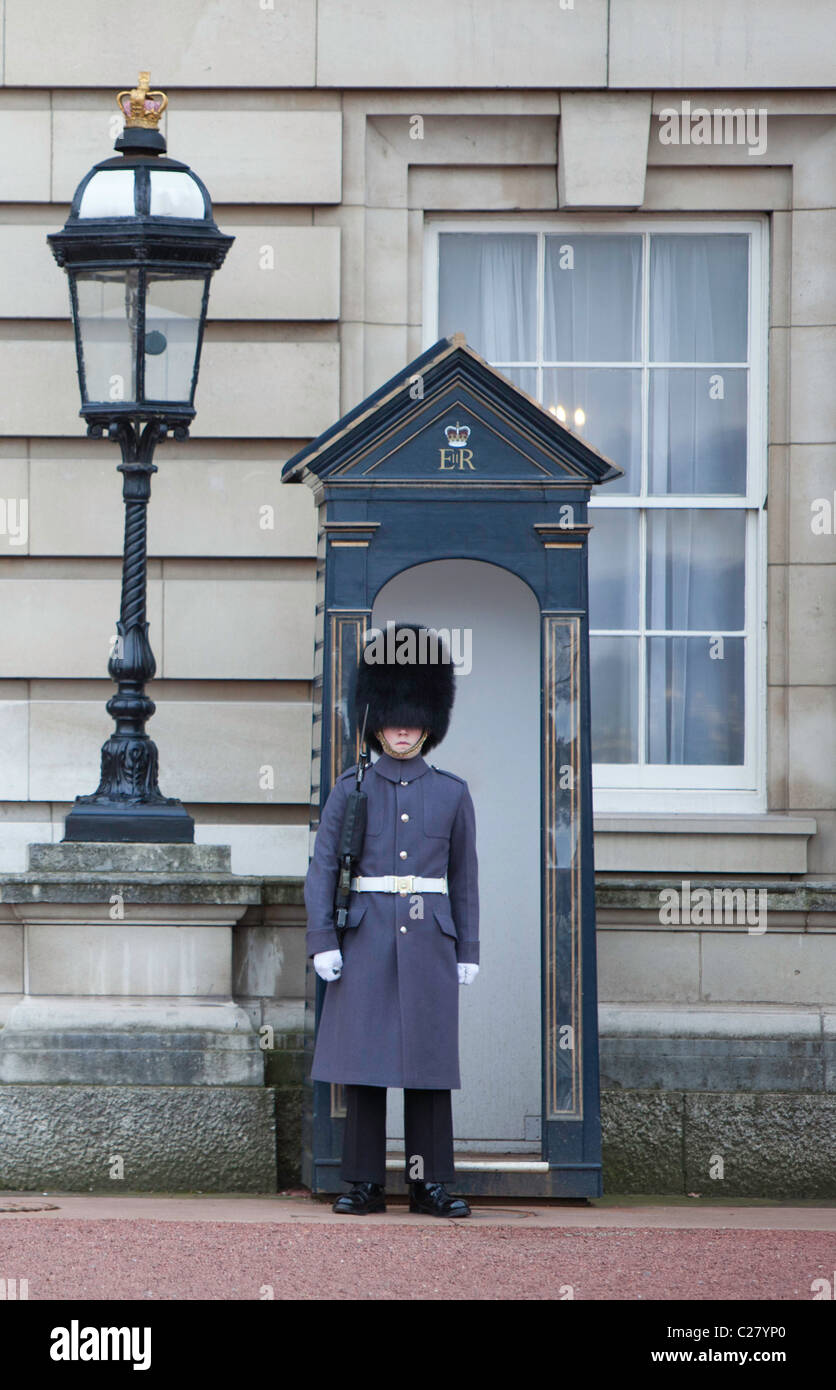A member of the Queens Guard patrols outside Buckingham Palace, the official London residence of the British monarch. Stock Photo