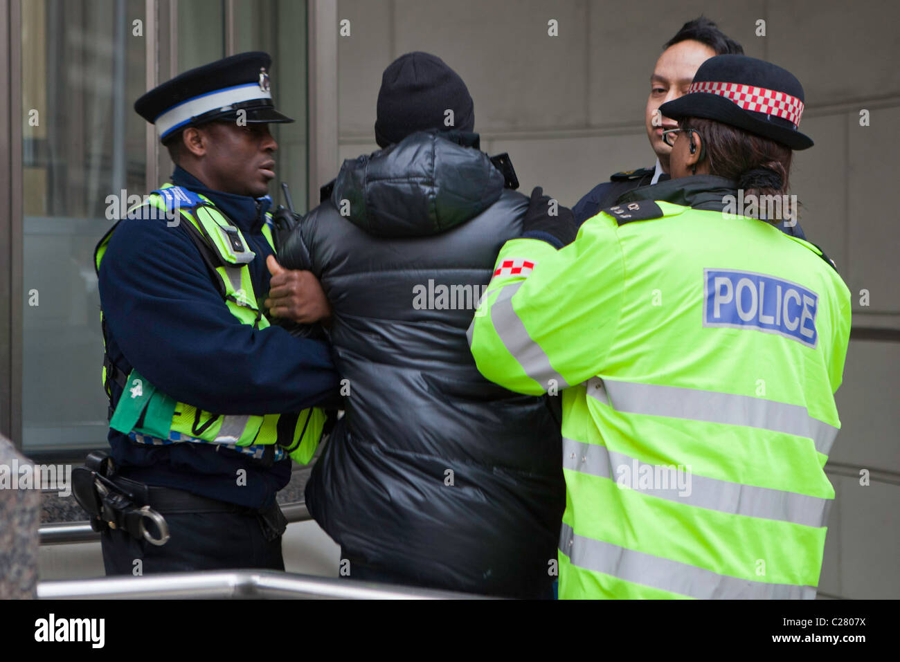 A young black male is arrested on Ludgate Hill. It took 10 police officers from various forces to overcome and arrest him. Stock Photo