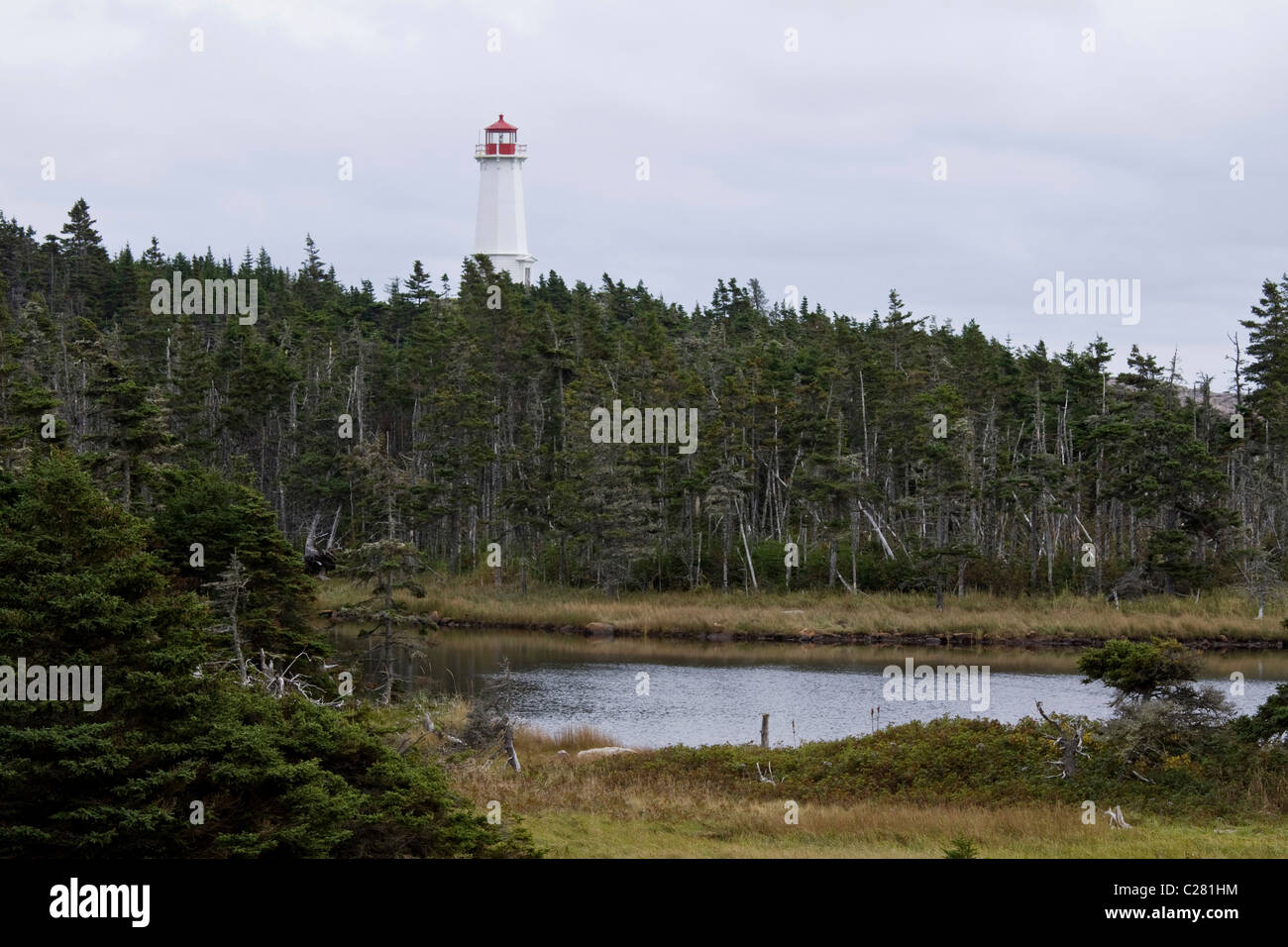 Lighthouse rising from the boreal forest, near Fortress of Louisbourg National Historic Site, Cape Breton, Nova Scotia, Canada Stock Photo
