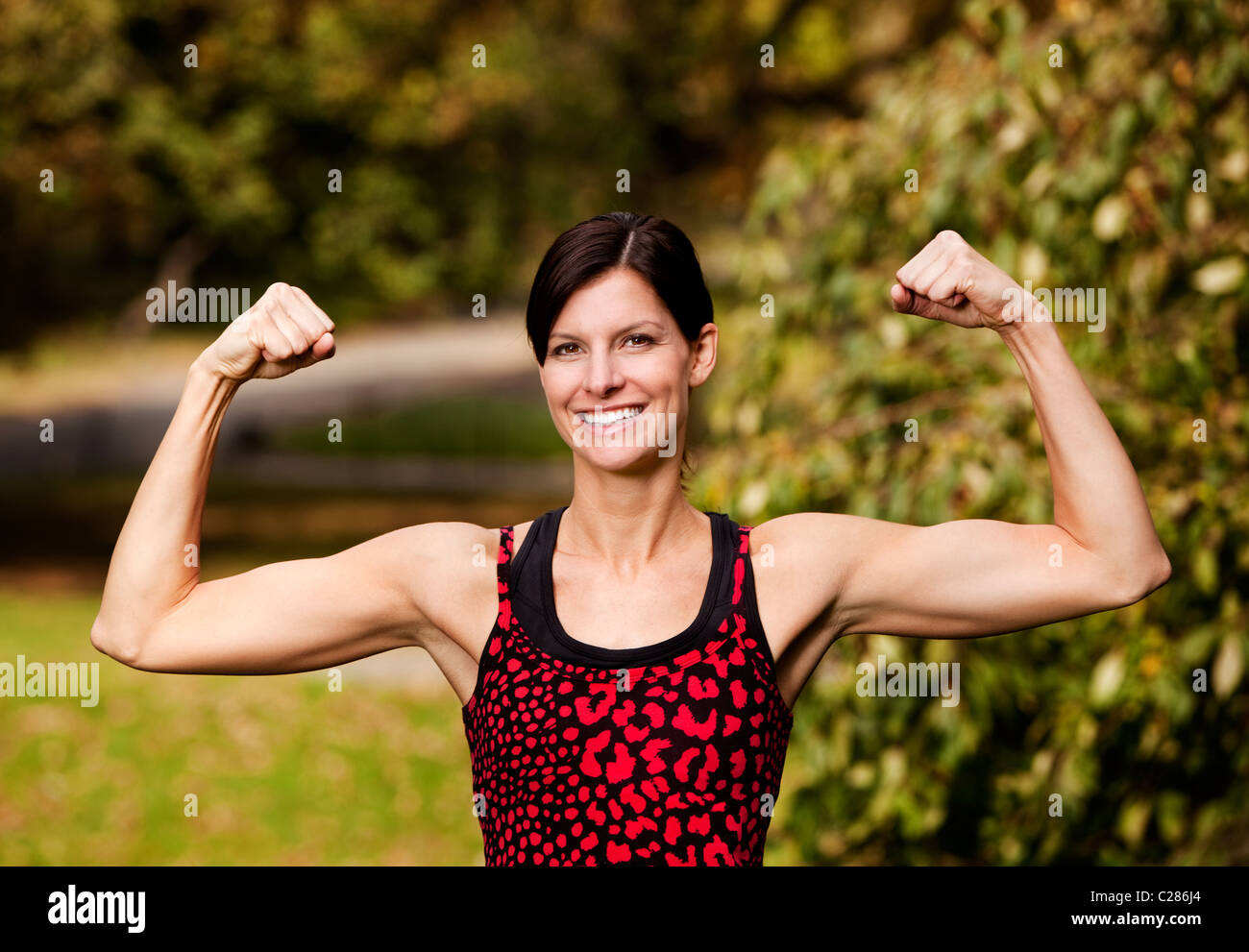 A female fitness model flexing her biceps Stock Photo - Alamy