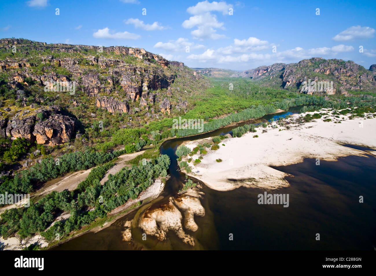 A river deposits large sand beaches at the mouth of a sandstone gorge. Stock Photo