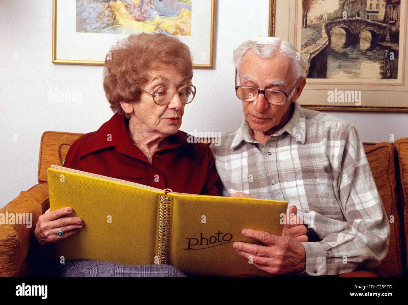 Elderly couple looking at a family photo album Stock Photo - Alamy