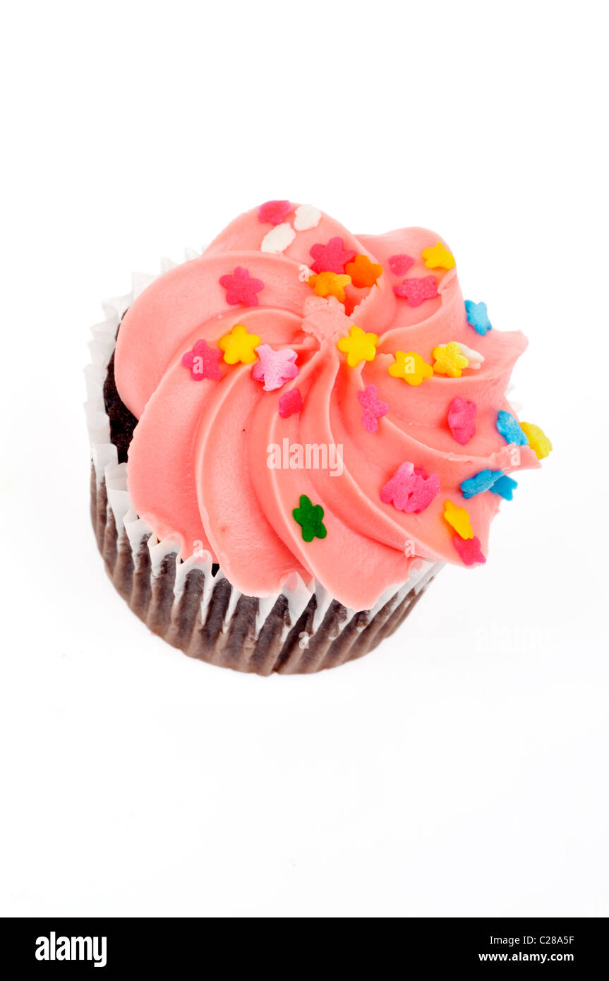 Chocolate cupcake decorated with pink frosted icing and colorful sprinkles on white background, cutout. Stock Photo