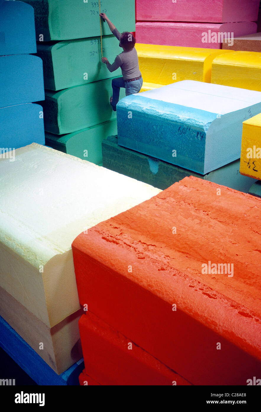Worker performing a quality control check at a foam rubber manufacturing facility Stock Photo