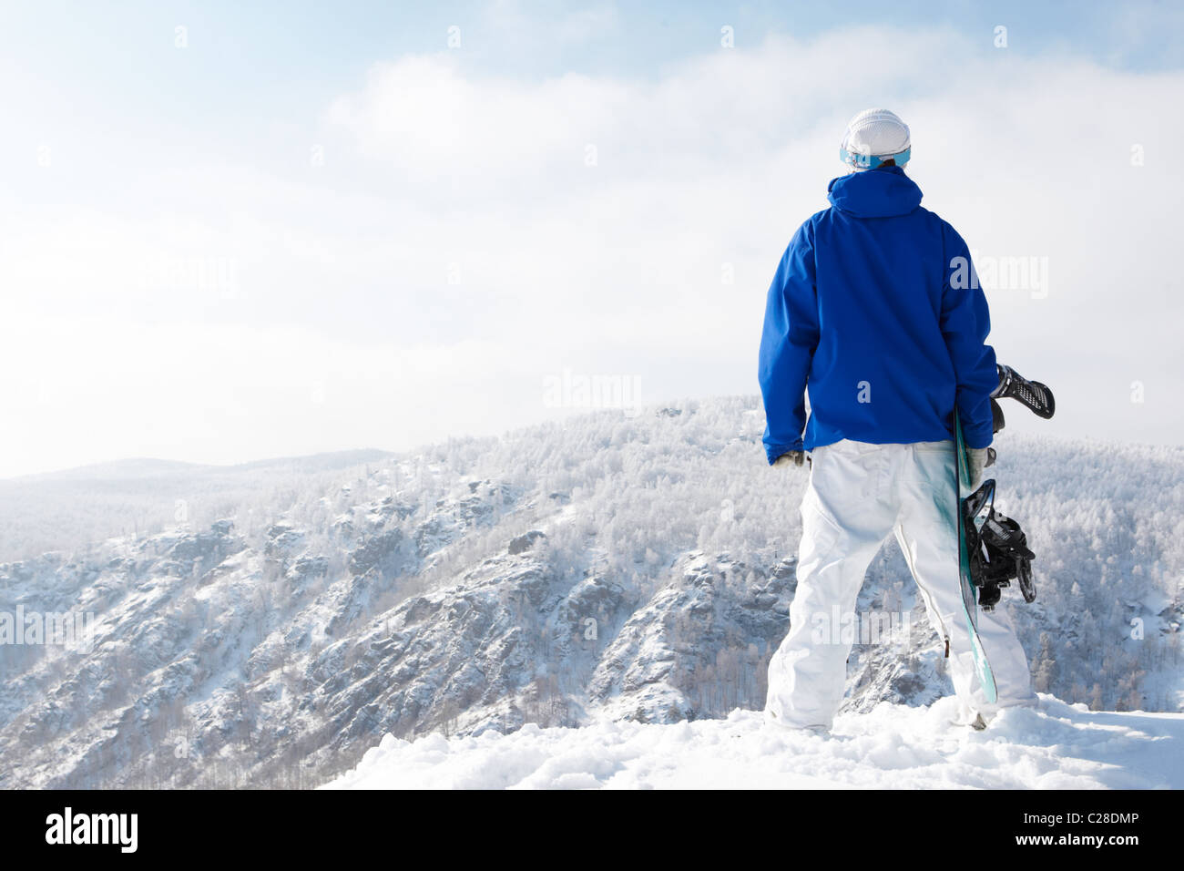 Rear view of sportsman with snowboard watching the nature Stock Photo ...