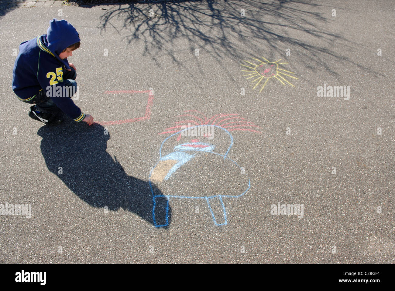 BOY DRAWING ON ASPHALT Stock Photo - Alamy
