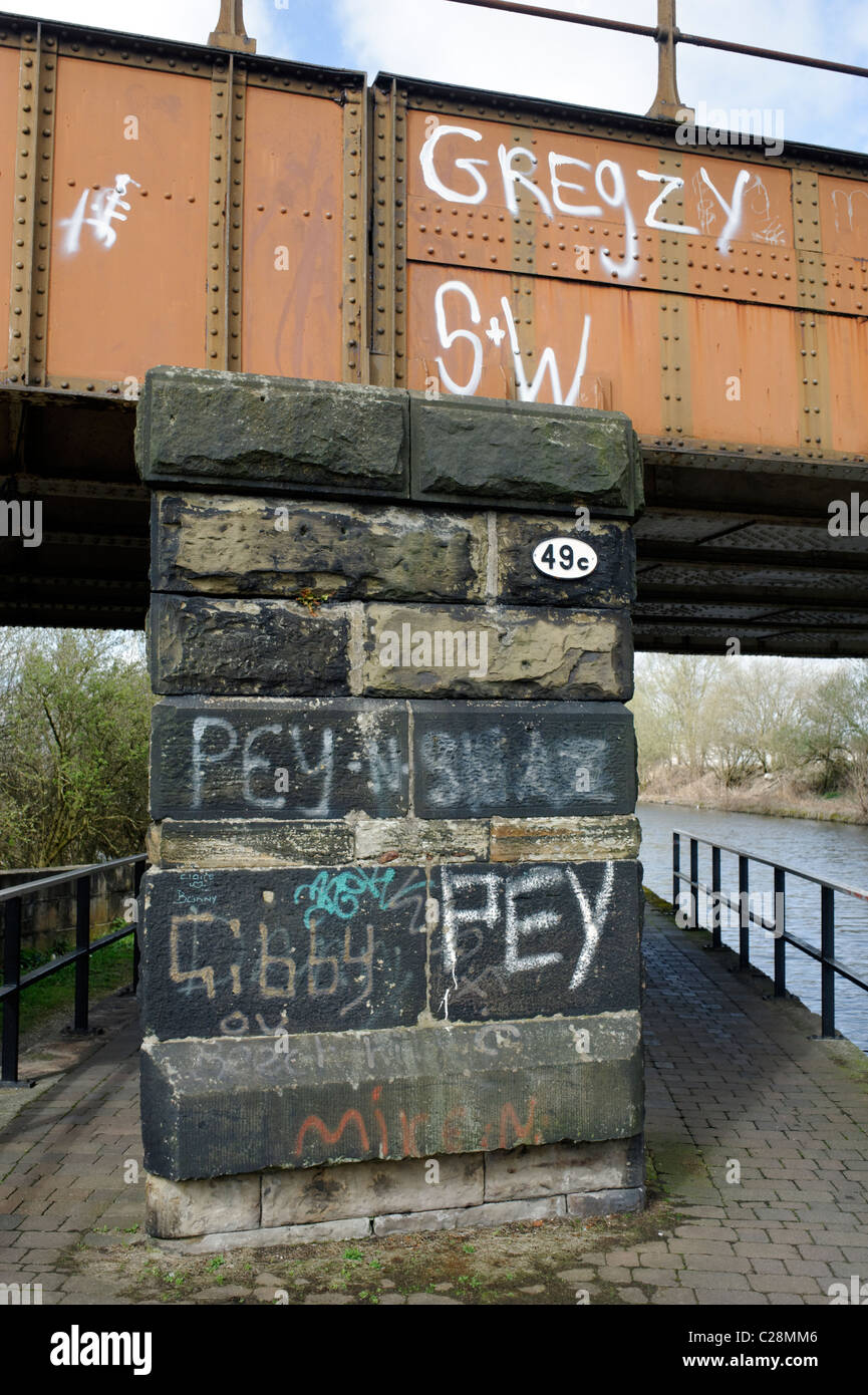 Graffiti on a railway bridge along at Leeds-Liverpool canal at Wigan Stock Photo