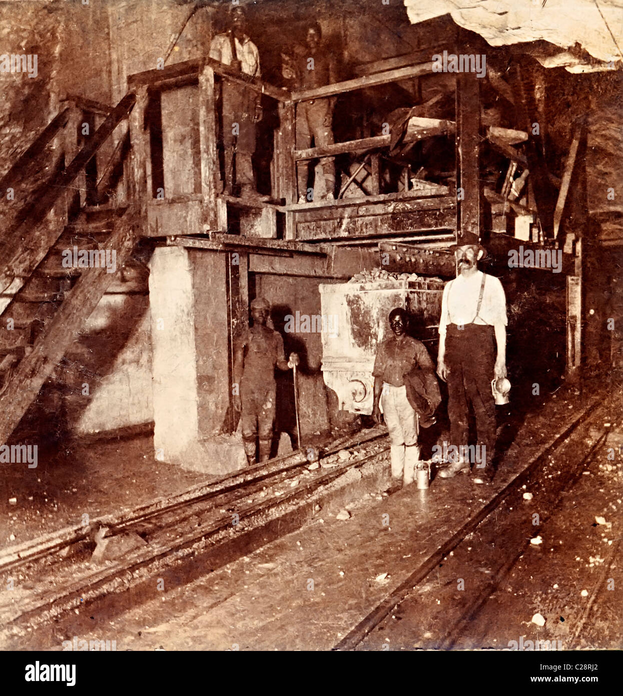 Miners with lamps at ore loading area Modder Gold Mine Witwatersrand Transvaal South Africa Stock Photo