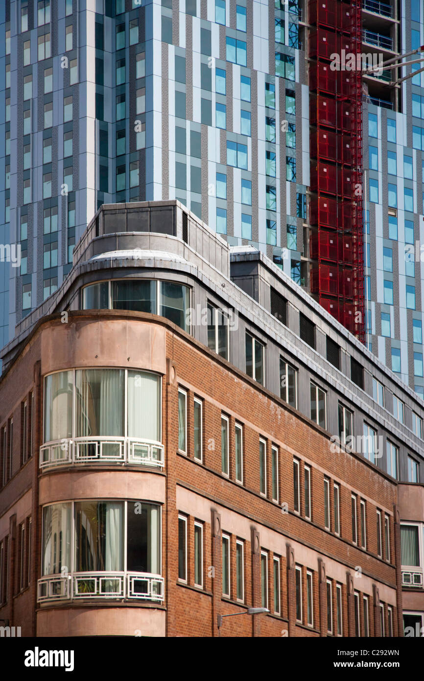 Old art deco brick building in front of a large glass skyscraper in central London Stock Photo