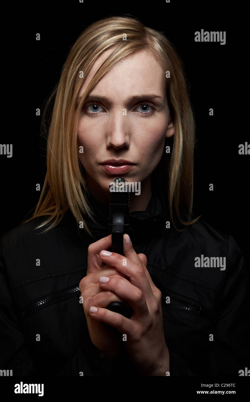 Woman holding gun in the dark Stock Photo