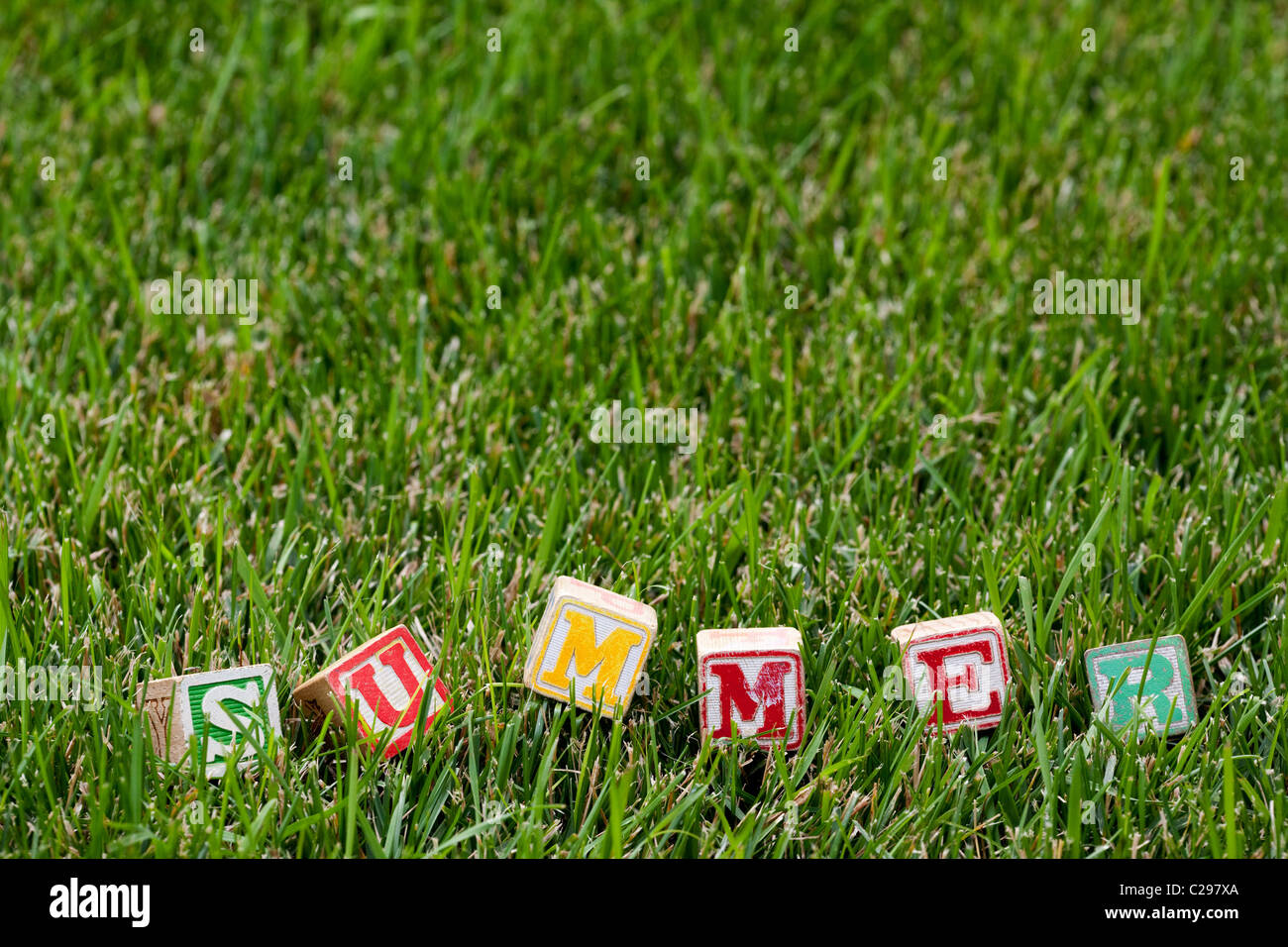 Wooden baby block spelling the word summer in grass Stock Photo Alamy