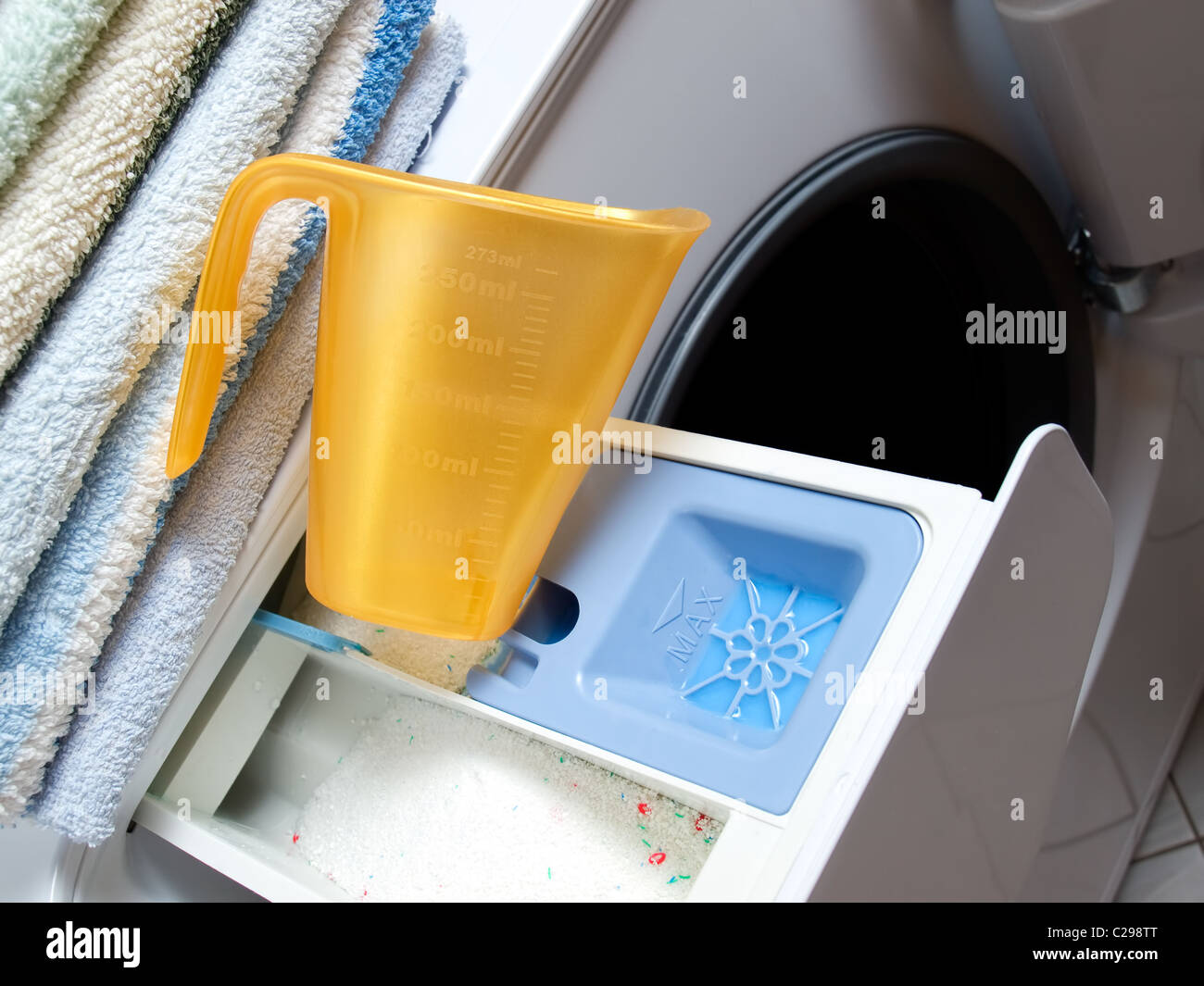 https://c8.alamy.com/comp/C298TT/closeup-view-of-measuring-cup-and-tub-for-dispensing-detergent-in-C298TT.jpg