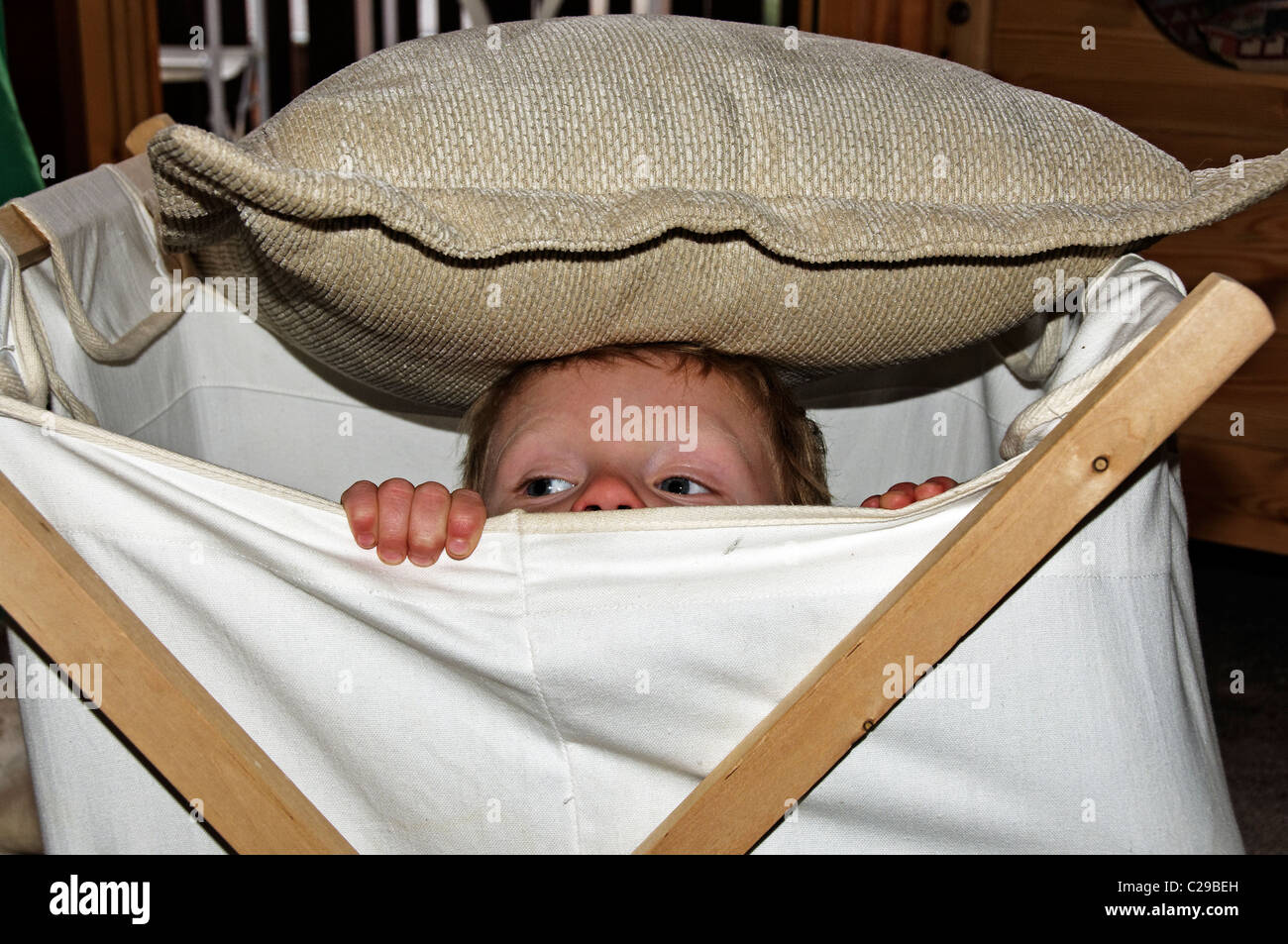 A young boy hiding in a laundry basket Stock Photo - Alamy