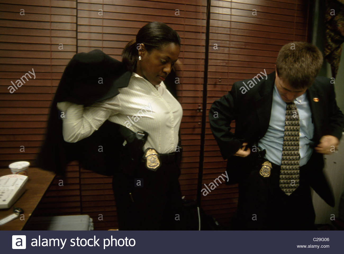 Two Secret Service Agents Put On Jackets Displaying Guns And Badges two-secret-service-agents-put-on-jackets-displaying-guns-and-badges