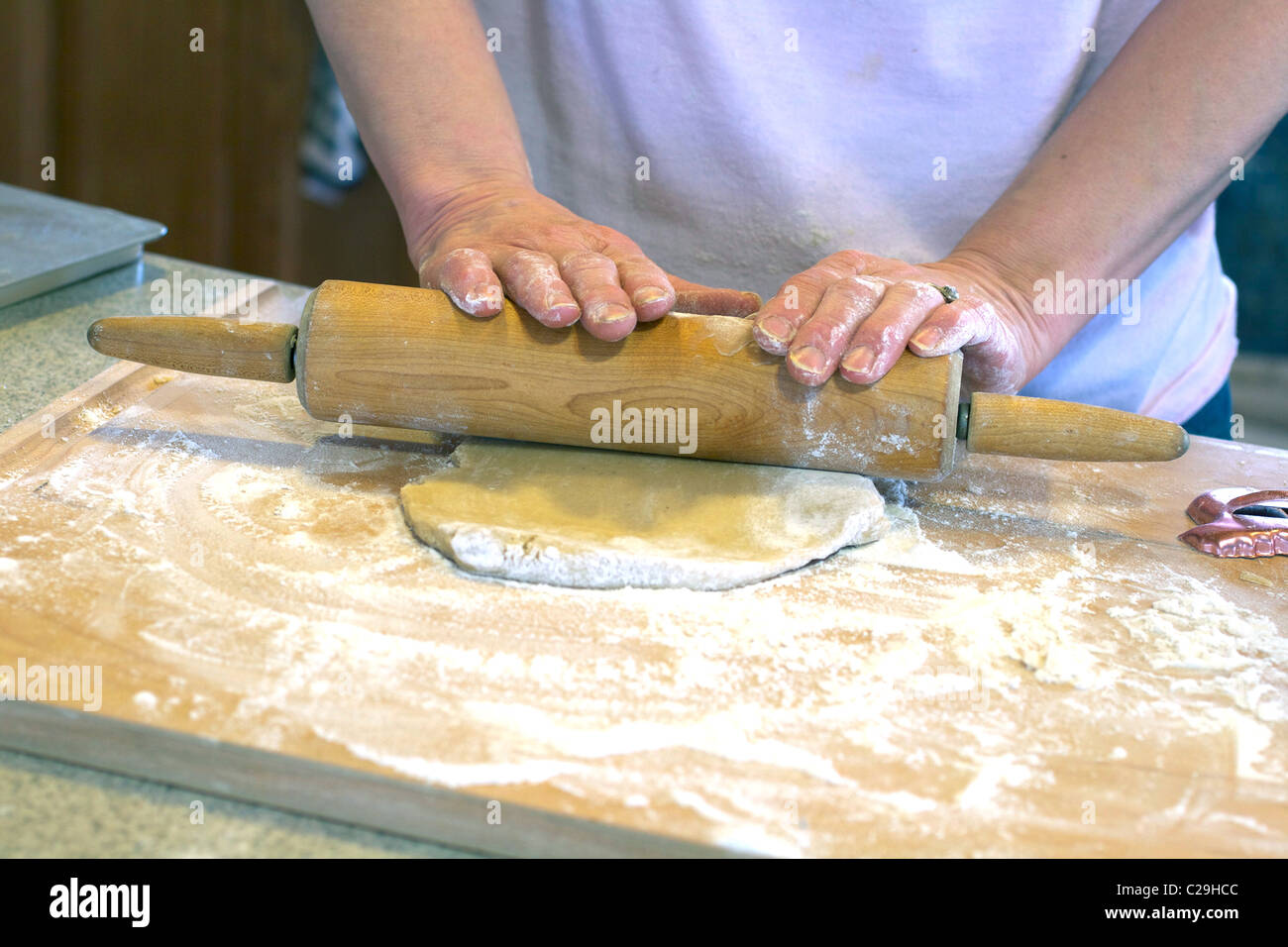 Baker using a rolling pin to roll out dough Stock Photo Alamy