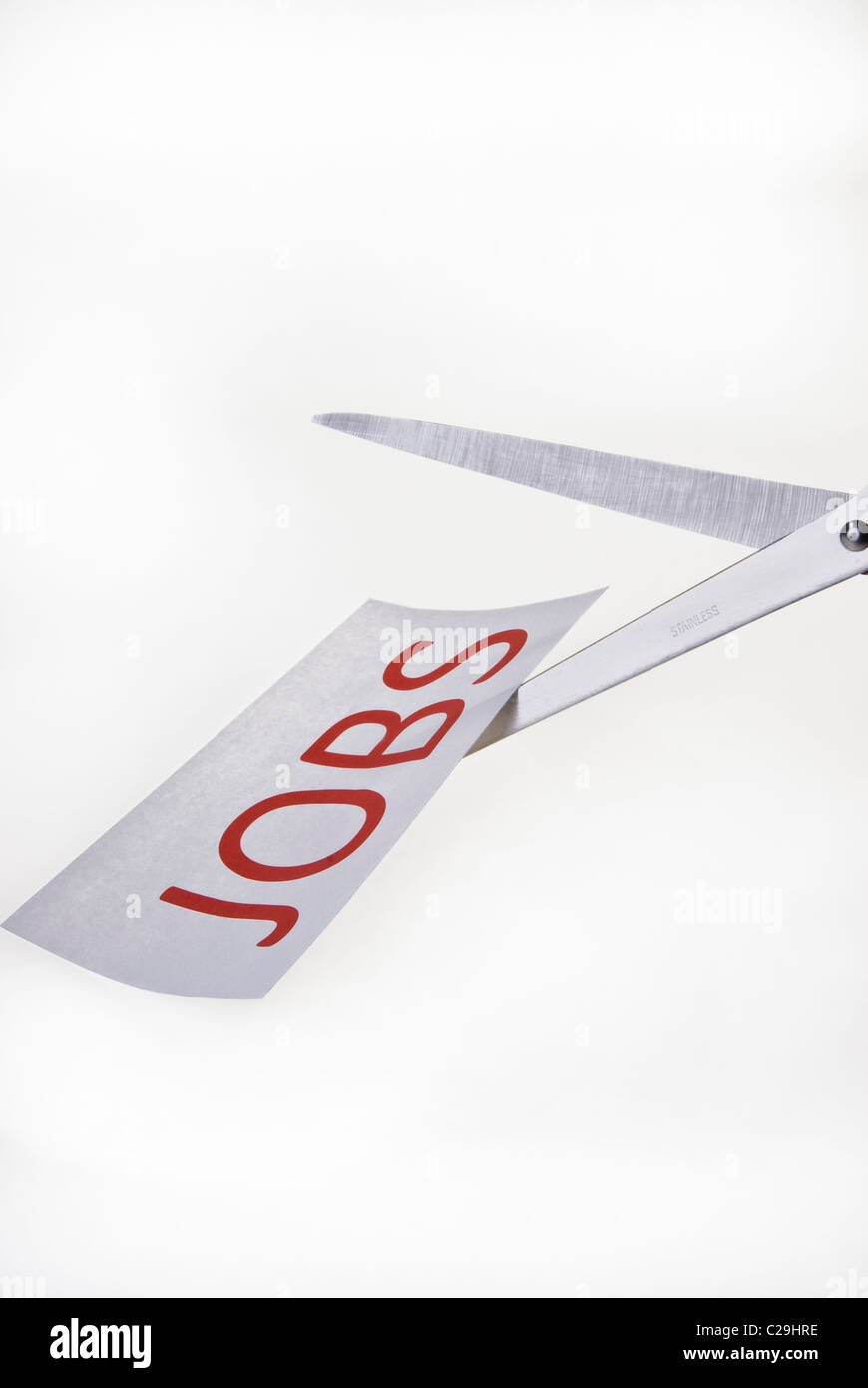 Job Cuts. Scissors cutting paper. Stock Photo