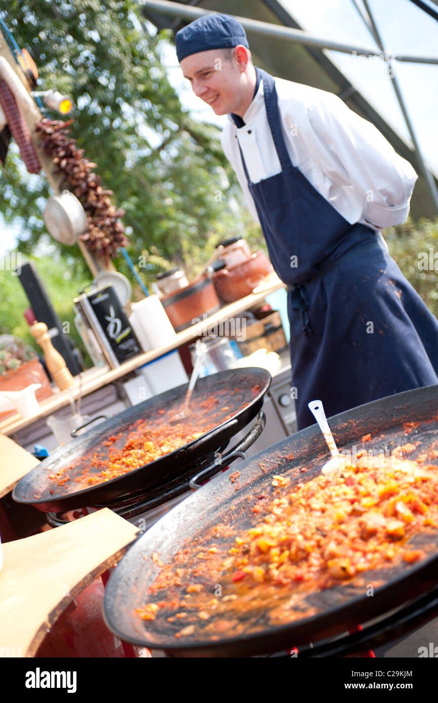 Professional chef cooking & serving traditional Spanish food at the Eden Project, Cornwall, UK Stock Photo