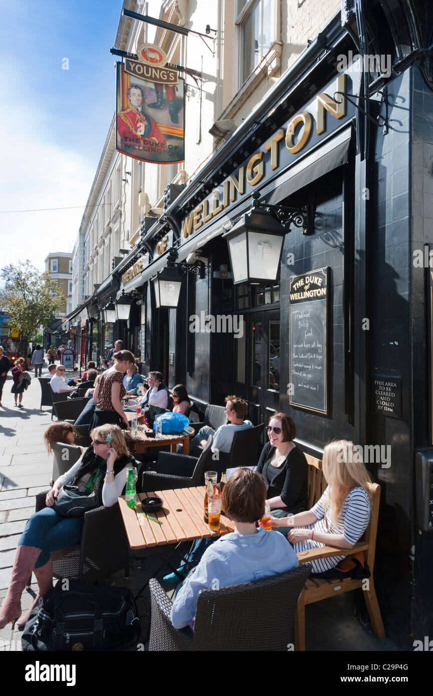 People enjoying some early summer sun outside the Duke of Wellington public house (pub) in Notting Hill, London, England, UK. Stock Photo