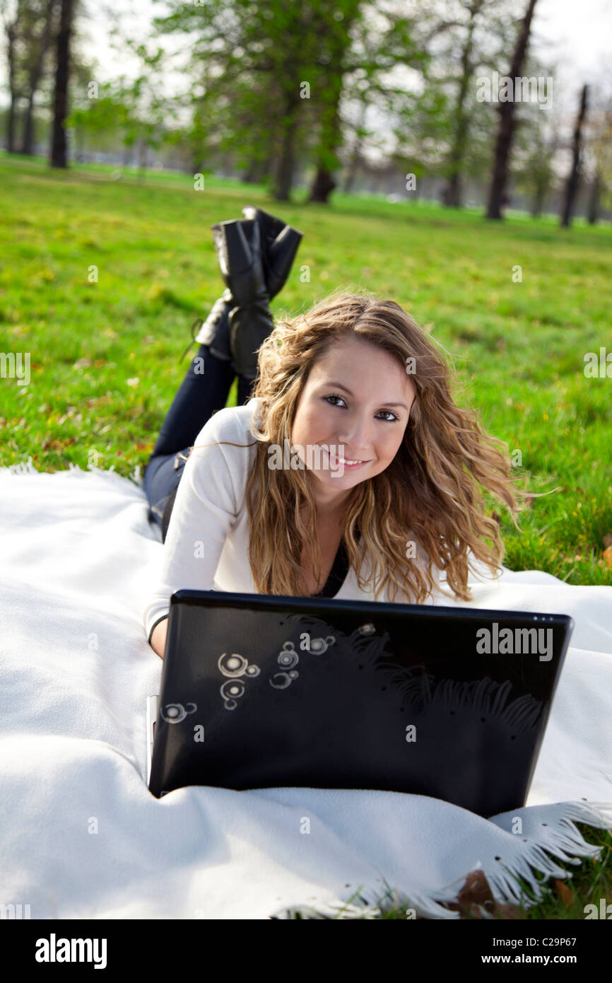 Young woman in park with laptop Stock Photo - Alamy