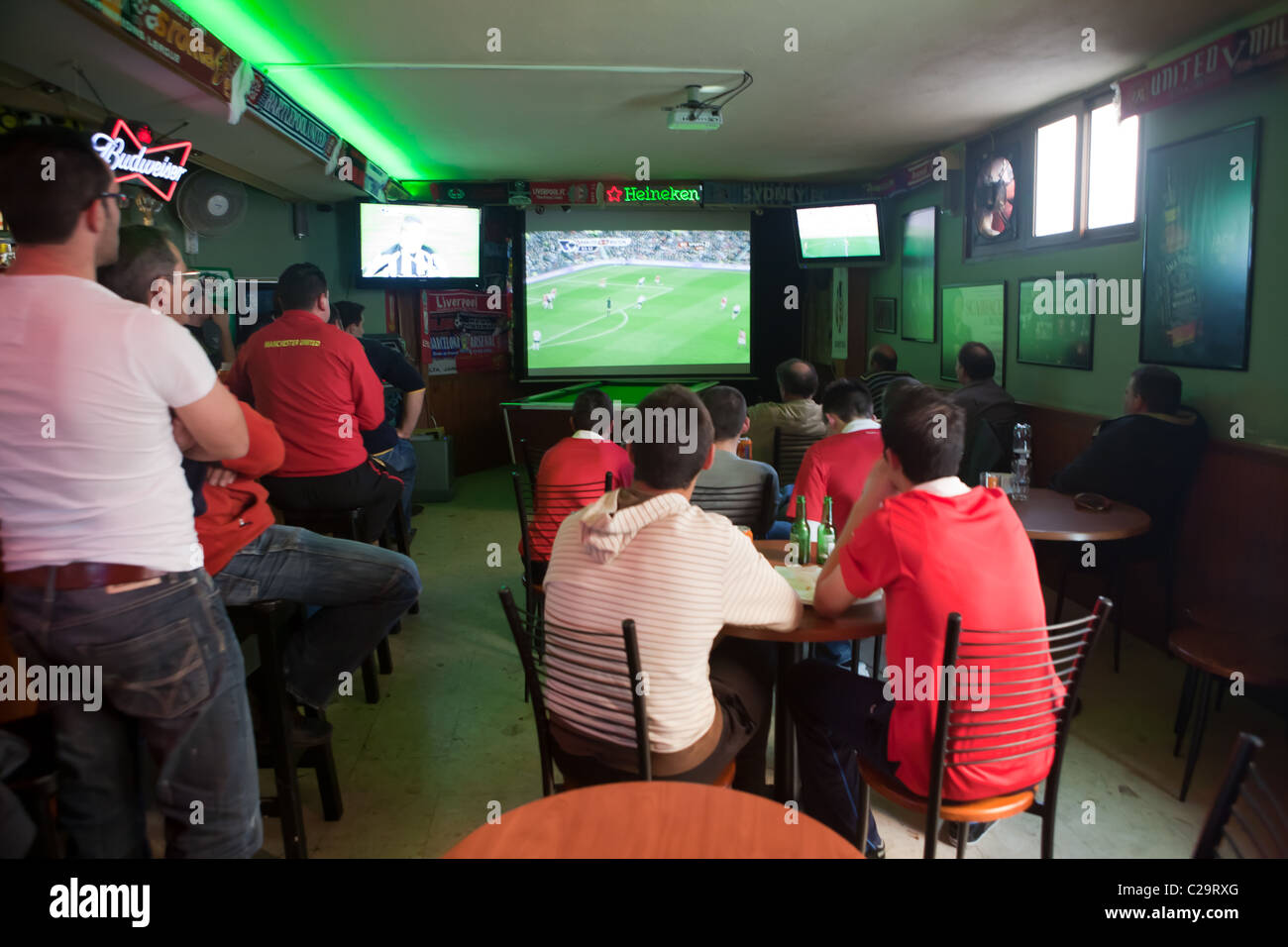 A group of men supporting Manchester United in a Maltese Bar Stock Photo