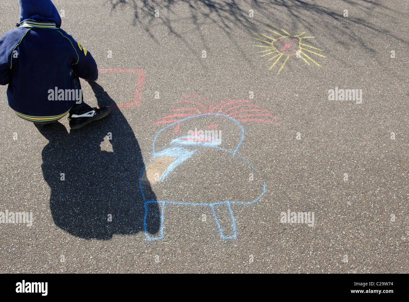 BOY DRAWING ON ASPHALT Stock Photo - Alamy