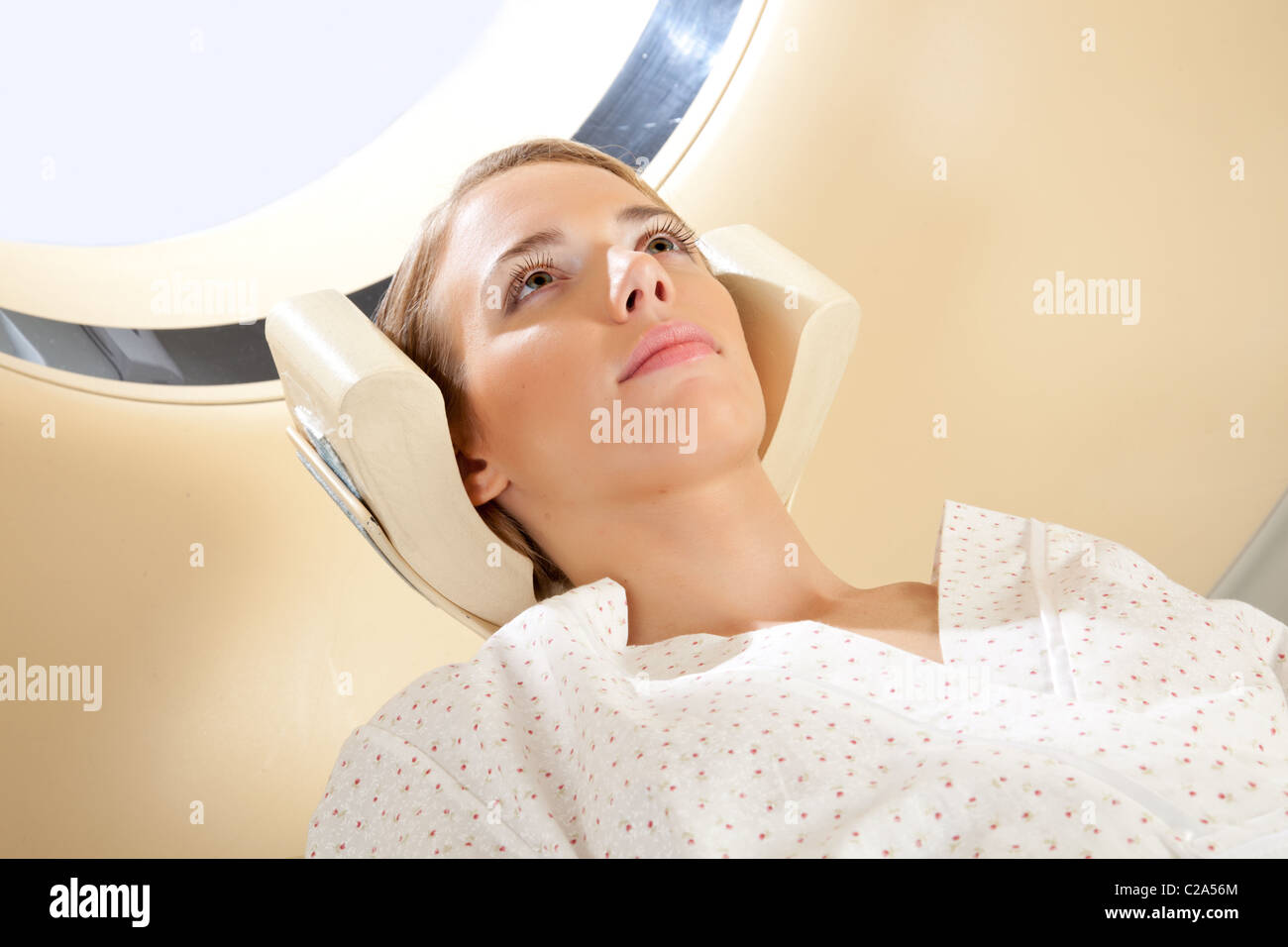 A young woman with eyes open preparing for a CT scan Stock Photo