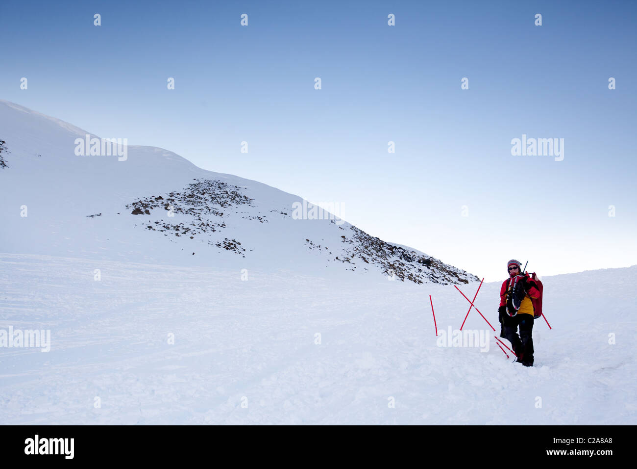 A female mountaineer on a snow filled slope, Svalbard, Norway Stock Photo