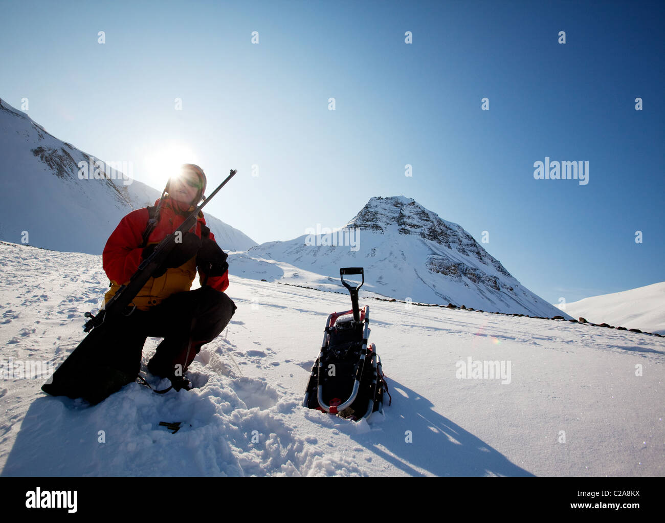 A female adventure loading a rifle as a safety precatuion, Svalbard, Norway Stock Photo