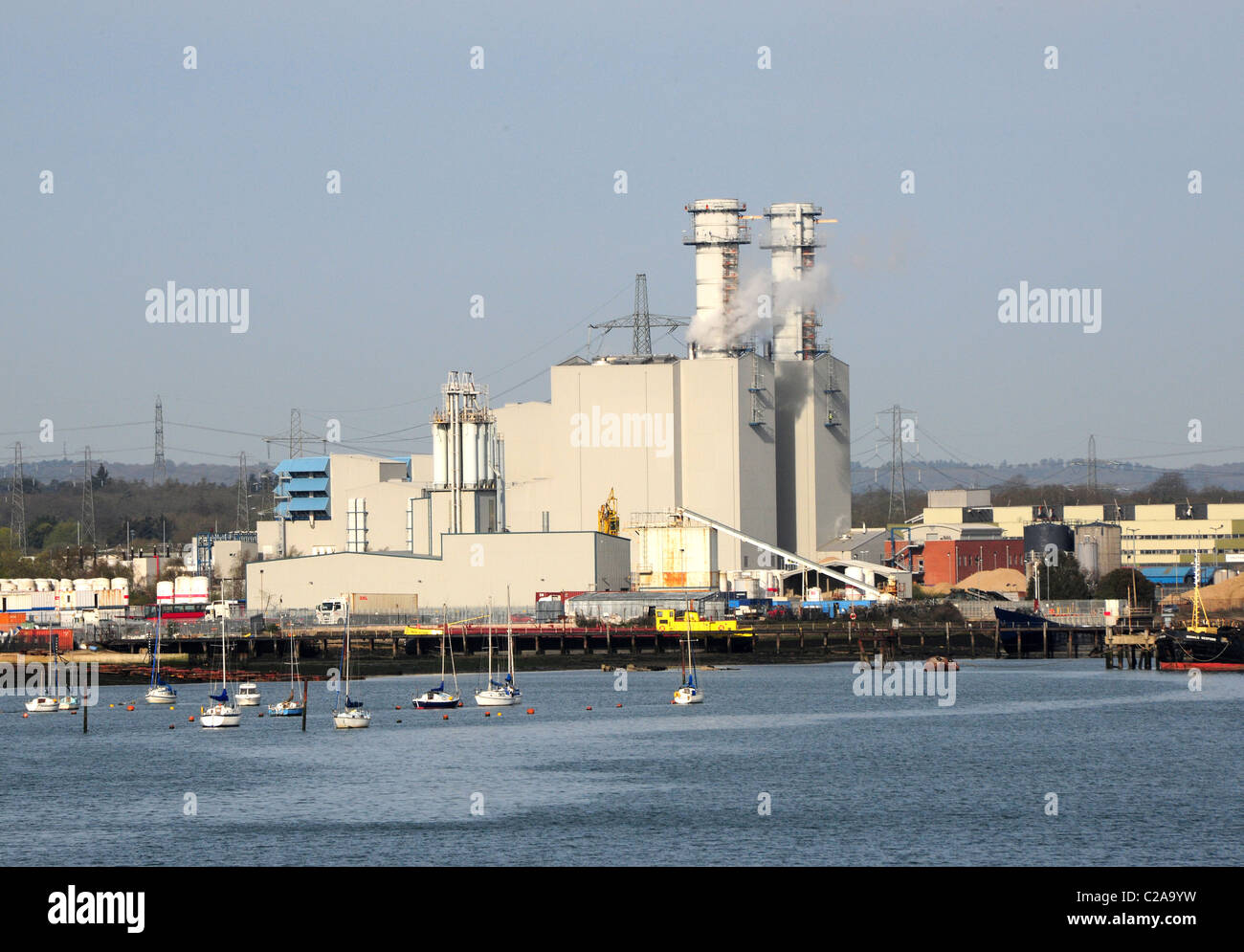 A modern natural gas fired power station by the waterfront, with boats. Stock Photo