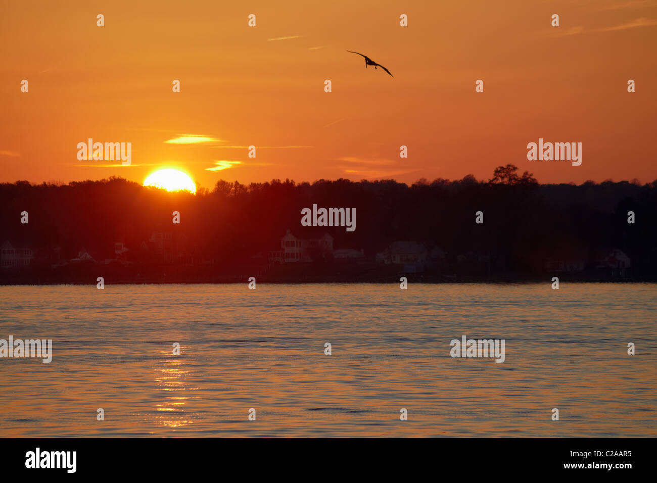 The sun sets over the Patuxent River as seen from the riverwalk on Solomon’s Island, Maryland. Stock Photo