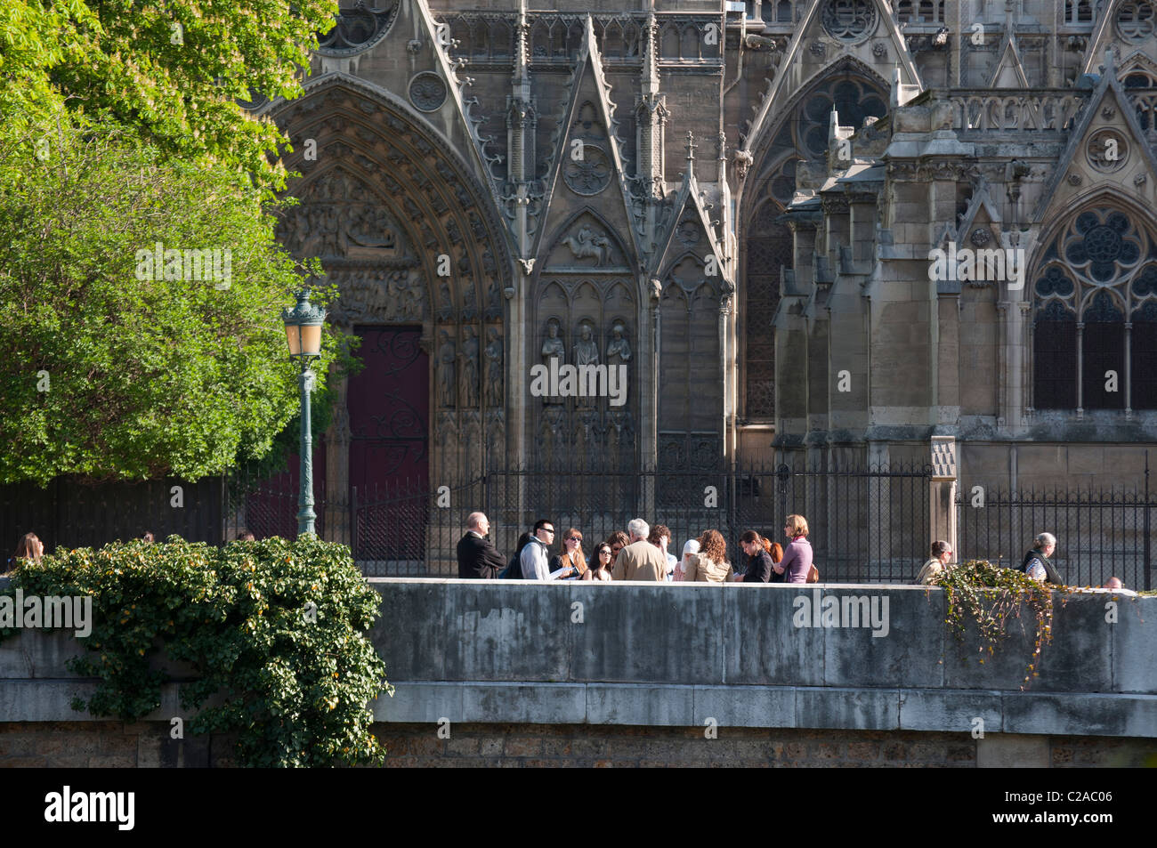 un groupe de touristes et leur guide à la cathédrale Notre Dame de Paris Group of tourists and their guide at Notre Dame Stock Photo