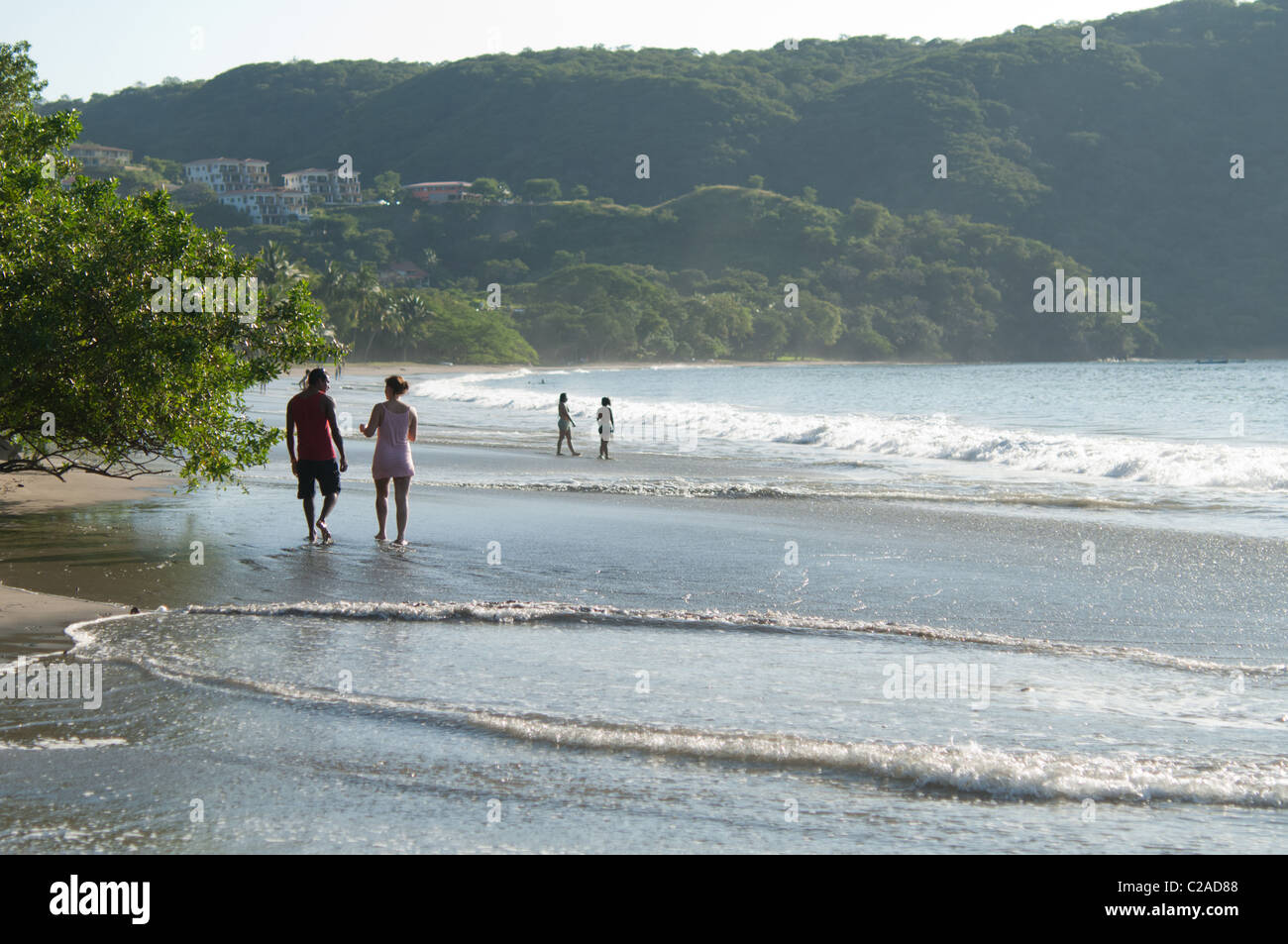 A couple walks down the beach in Playa Hermosa, Costa Rica. Stock Photo