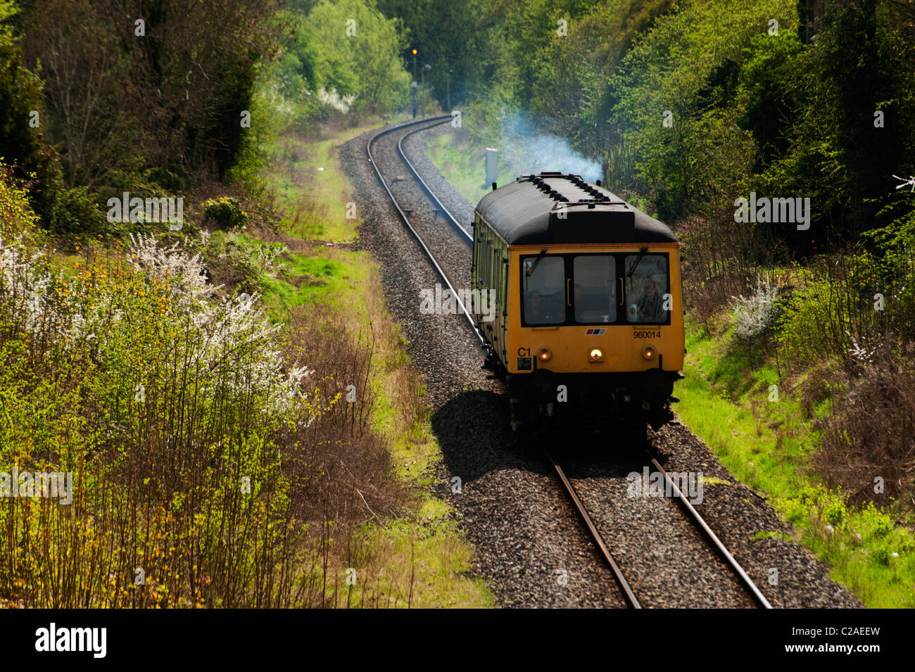 A single-car train running along the tracks north of Oxford in the spring. Stock Photo