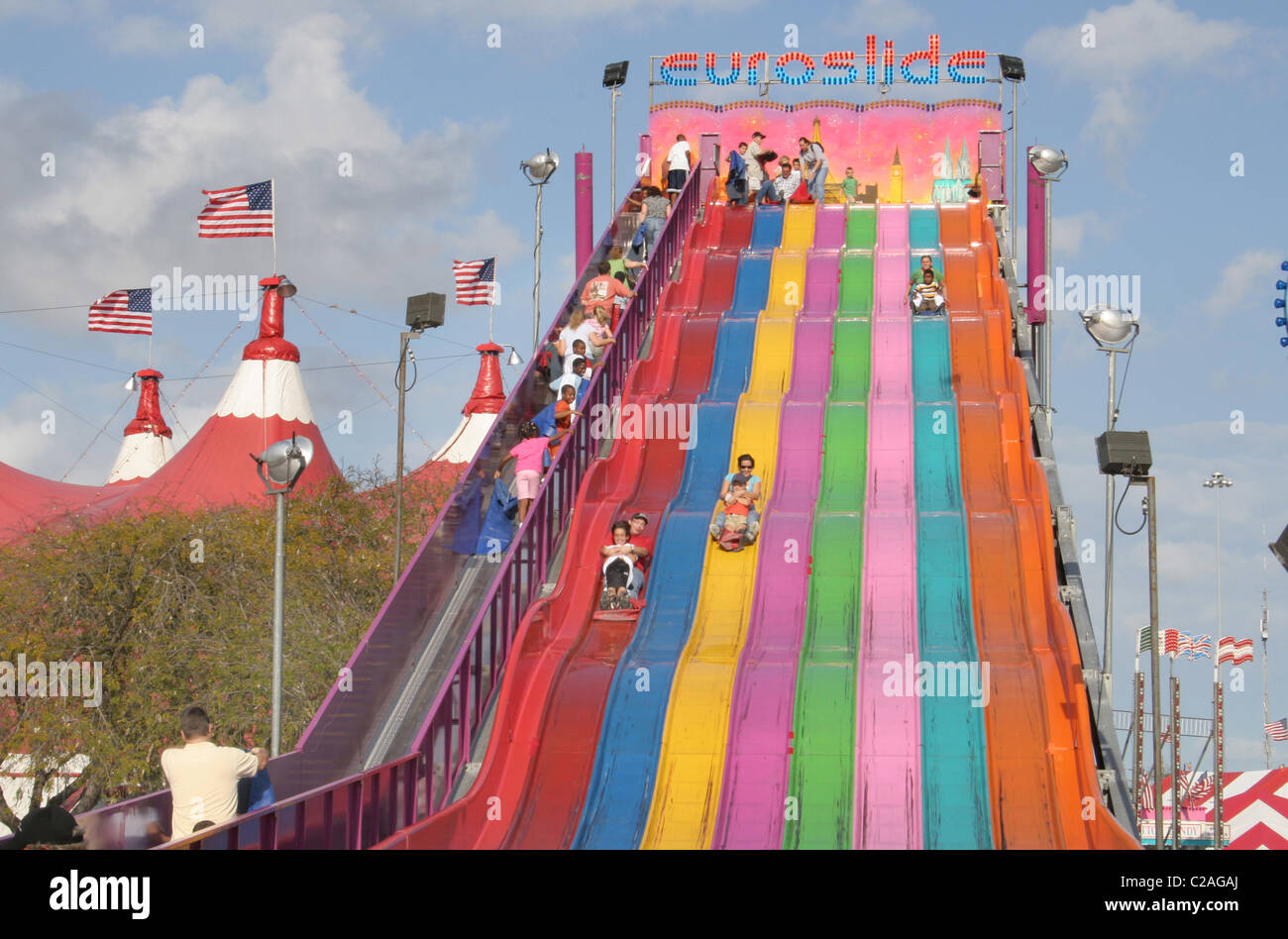 Ethnic kids down giant slide at Miami Dade County Fair Miami Florida Stock Photo