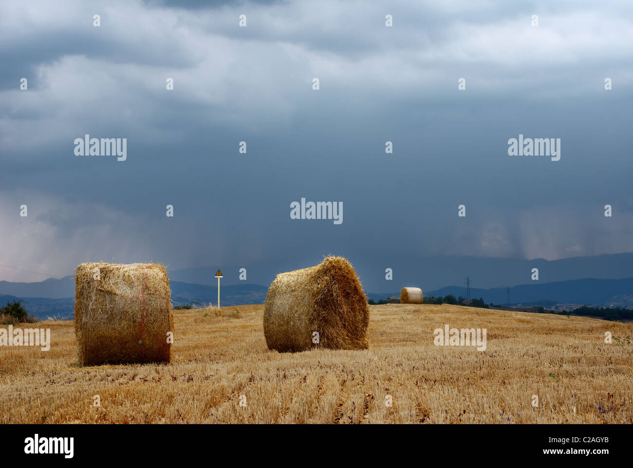 Straw bales in a field under moody sky Stock Photo