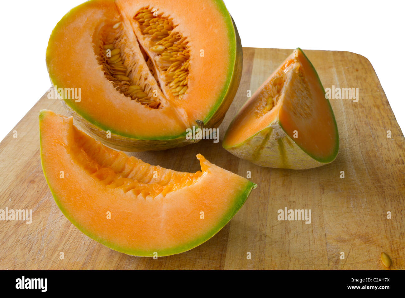sliced up fresh orange cantaloupe melon on wooden carving board Stock Photo