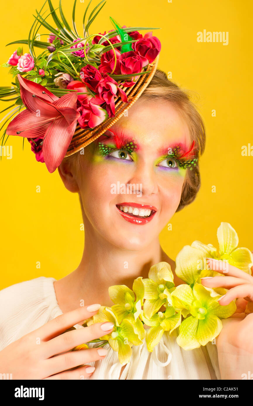 Beautiful young girl with creative flower cap and orchid flower ...