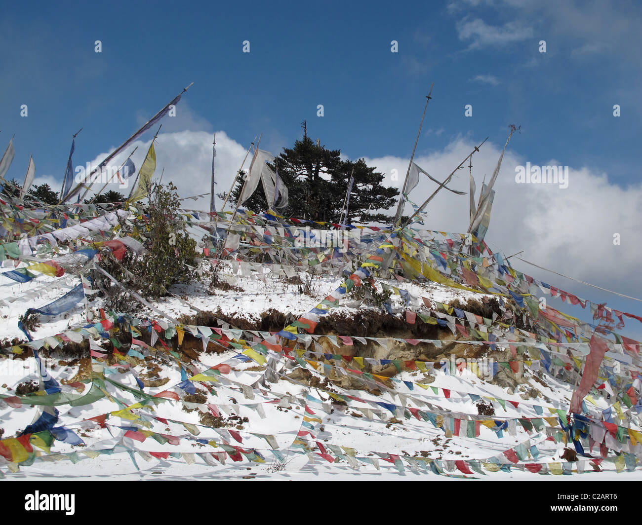 Snow and prayer flags at Thrumshingla Pass, the border between central and eastern Bhutan Stock Photo